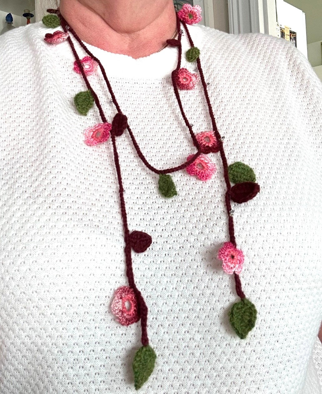 Virkat halsband/dekorband med rosa/vinröda blommor