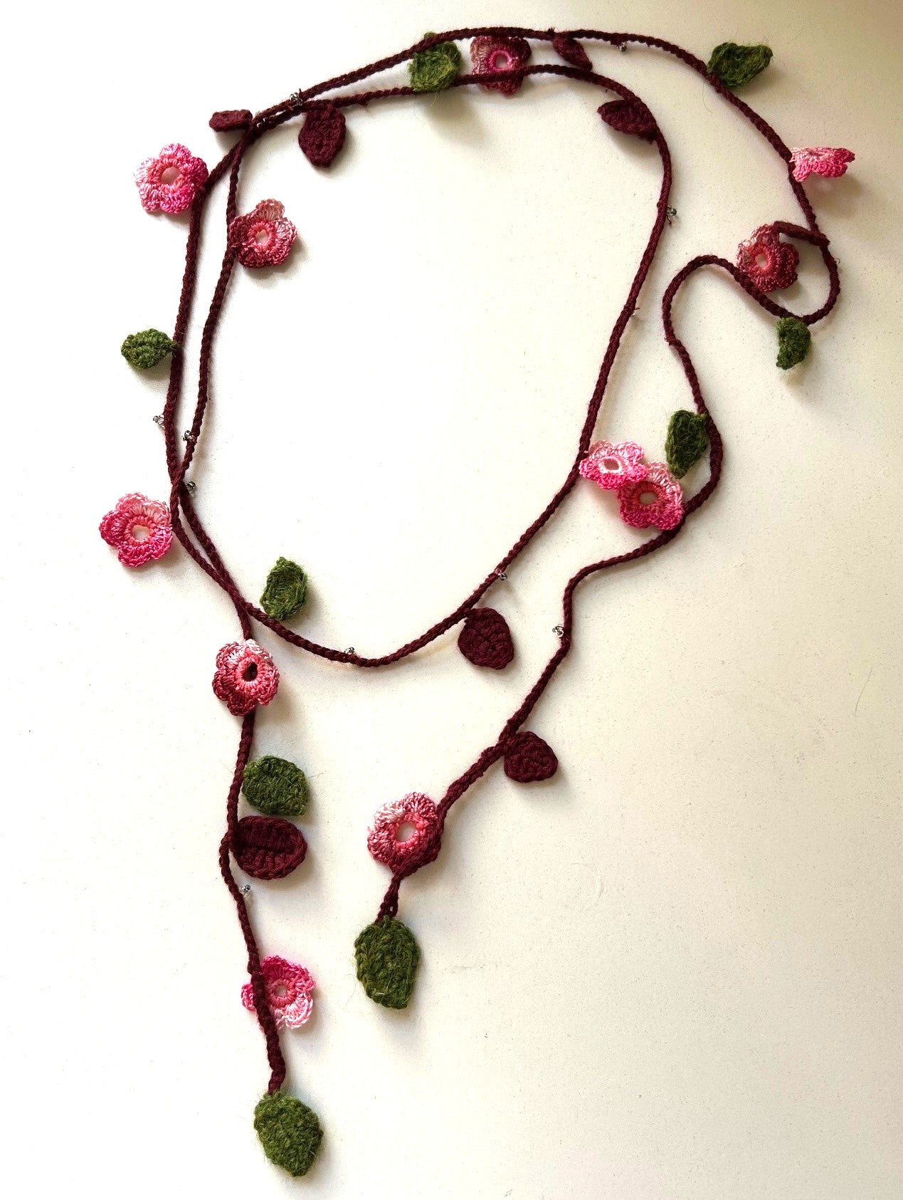 Virkat halsband/dekorband med rosa/vinröda blommor