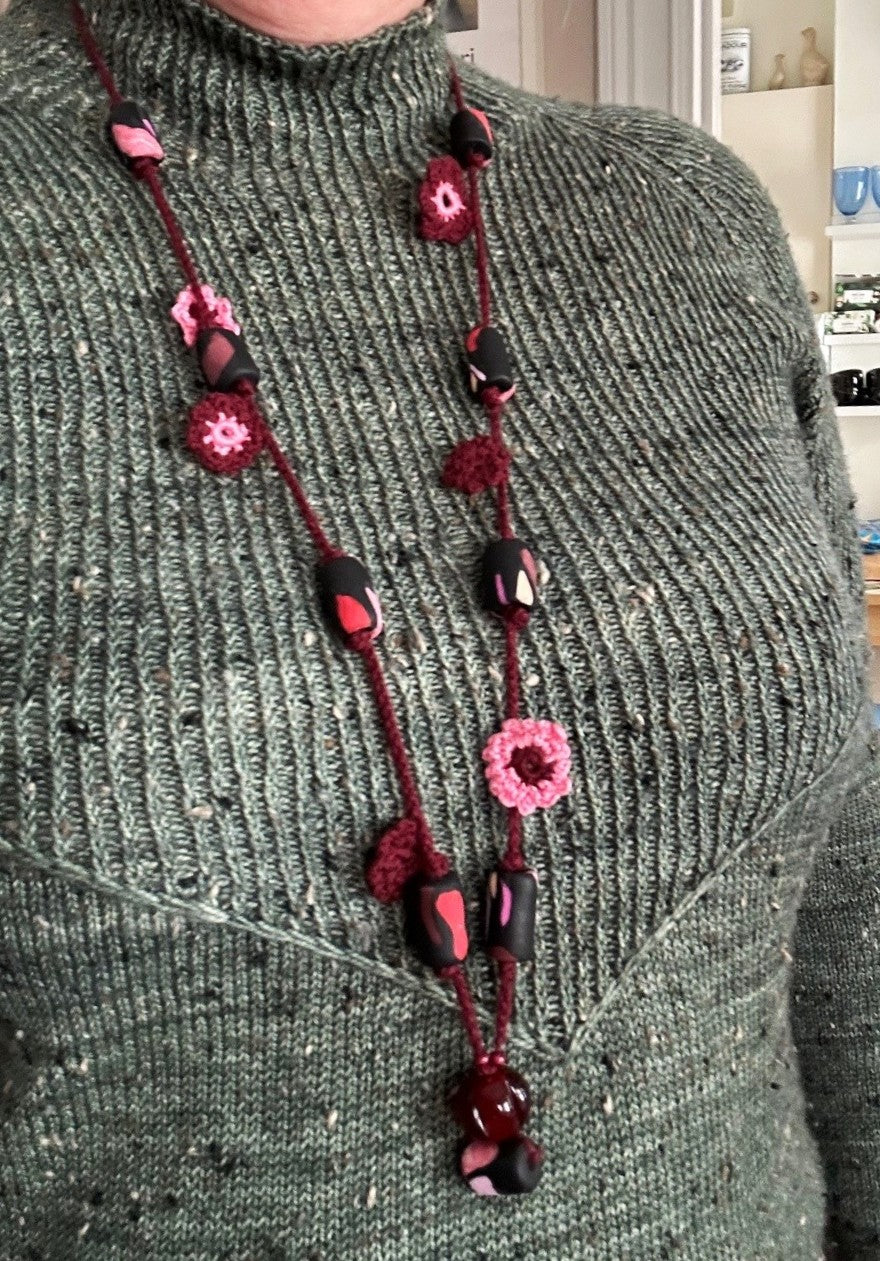 Virkat halsband med vinröda och rosa blommor