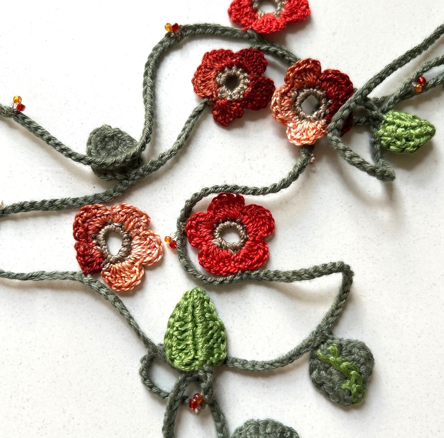 Virkat halsband/dekorband med orangemelerade blommor