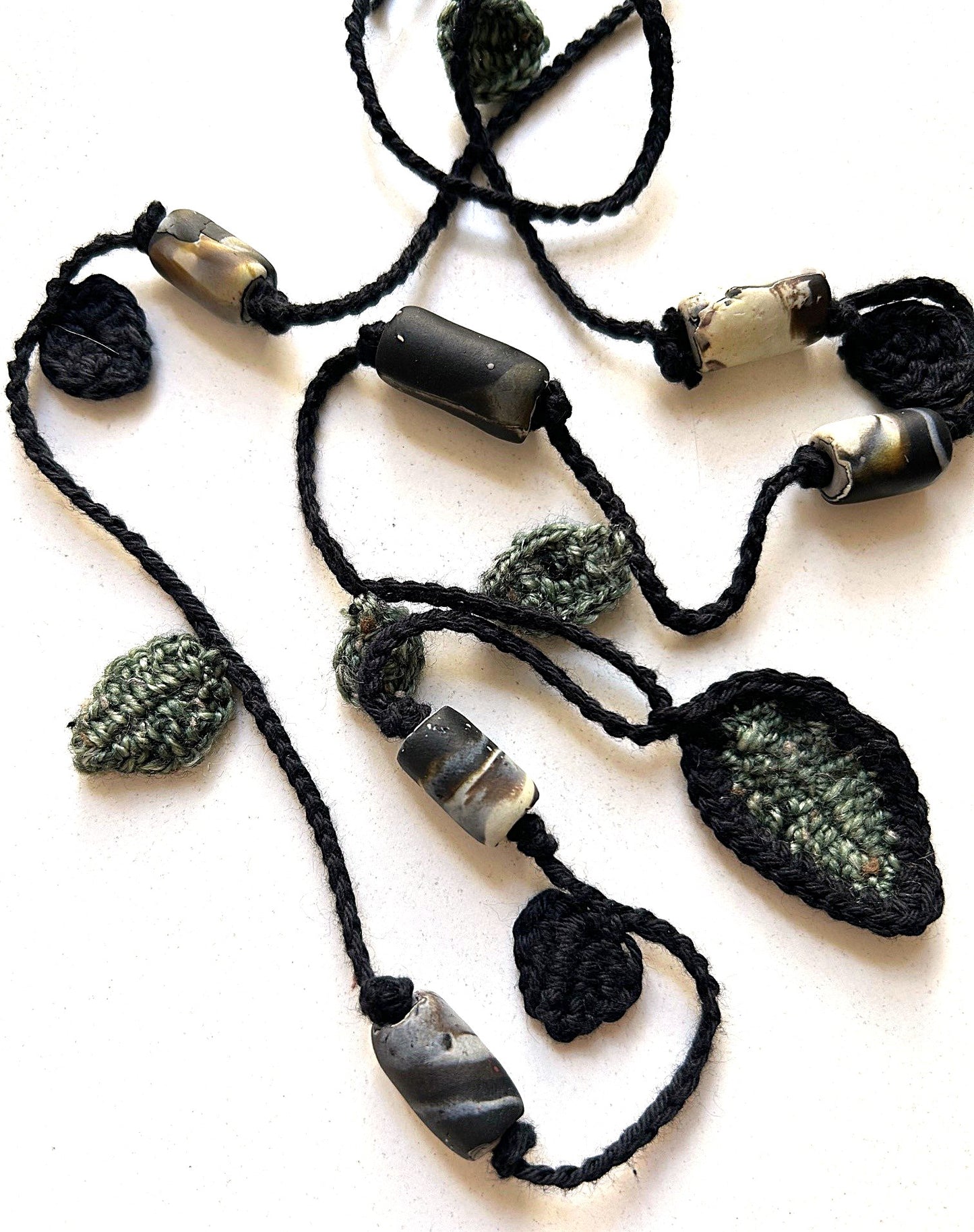Virkat halsband med gröna och svarta blad