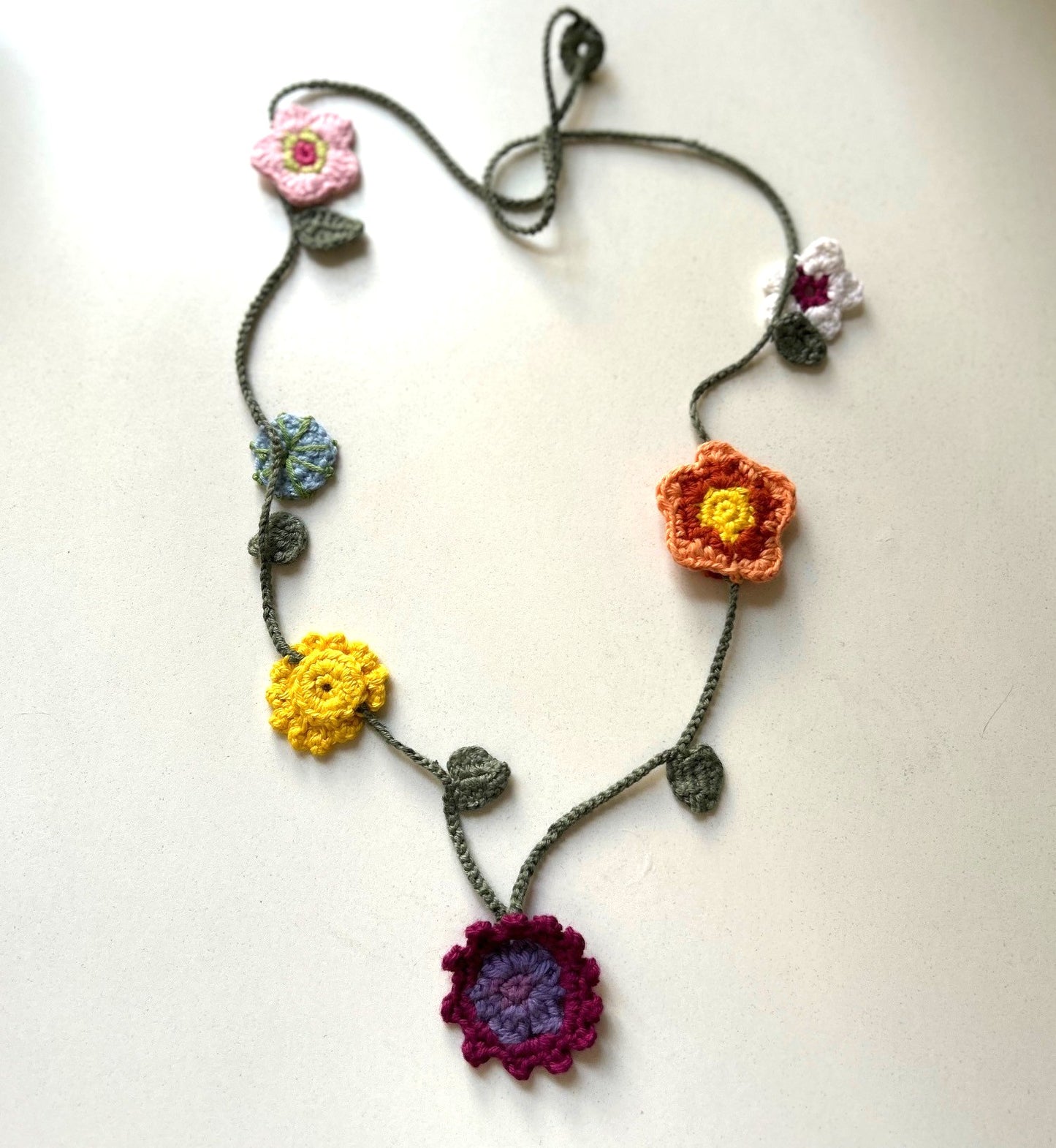 Virkat halsband med blommor i olika färger